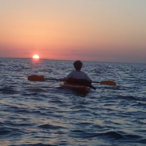 person watching a sunset from a kayak